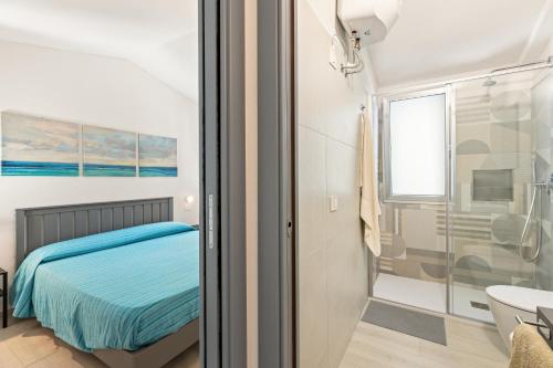 a small bedroom with a bed and a shower at Sabbiamare Torre dei Corsari in Torre Dei Corsari