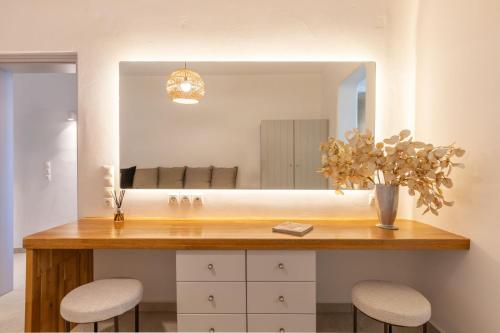 a bathroom with a counter with two stools and a mirror at Villa Sun Sky in Aggelika