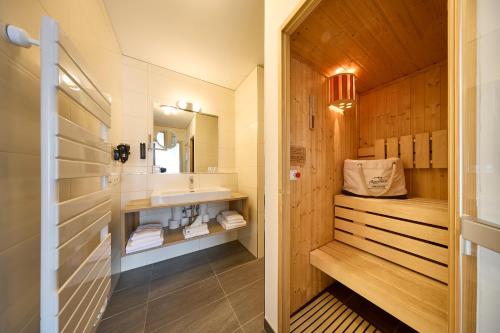 a bathroom with a sink and a mirror at AlpenParks Hotel & Apartment Sonnleiten in Saalbach-Hinterglemm