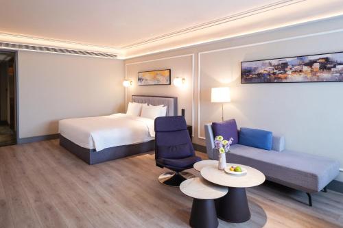 a hotel room with a bed and a table and a couch at Mercure Xi'an Qujiang in Xi'an