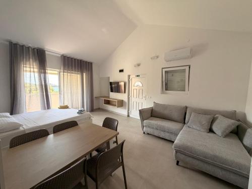 a living room with a bed and a couch and a table at Apartmani Tepli Bok in Primošten