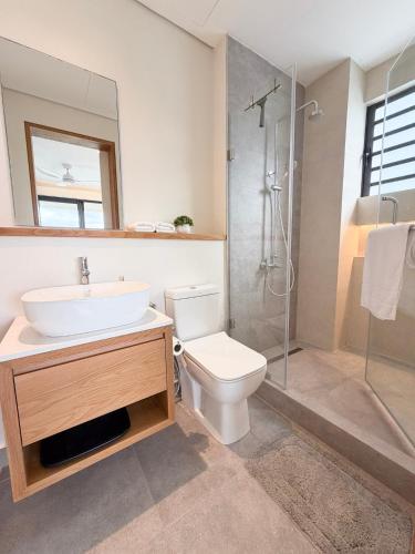 a bathroom with a toilet and a sink and a shower at Asmara Residence 2 Bedroom Apartment by LOV Mauritius, Beach Access in Petite Case Noyale