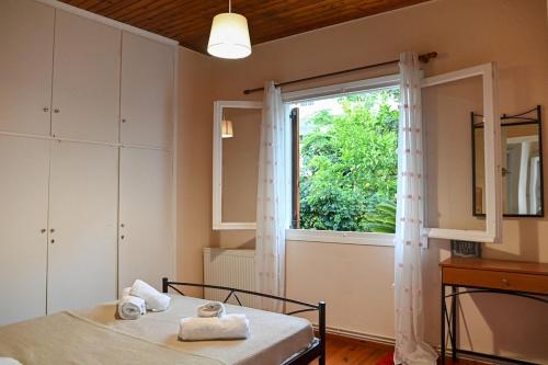 a bedroom with a bed and a large window at BotaniCasa by WENS in Preveza