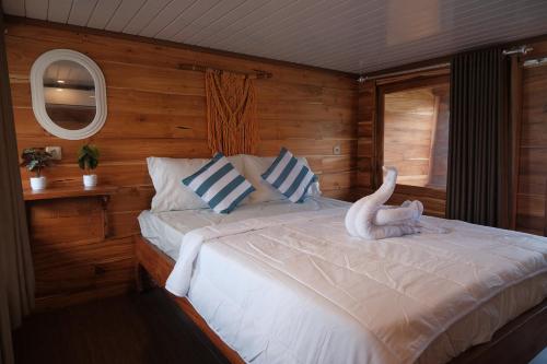 a bedroom with a bed with a white animal on it at Phinisi Private trip Komodo Island in Komodo Labuan Bajo Airport