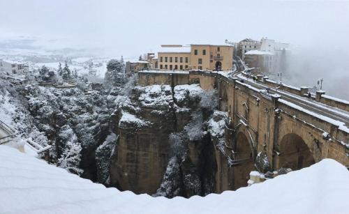 a city covered in snow with a bridge at Hotel Don Miguel in Ronda