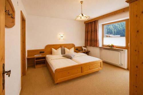 a bedroom with a bed with a desk and a window at Top Tirol Appartement in Längenfeld