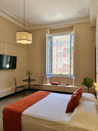 a bedroom with a bed and a window and a table at Hotel Fernanda in Rapallo