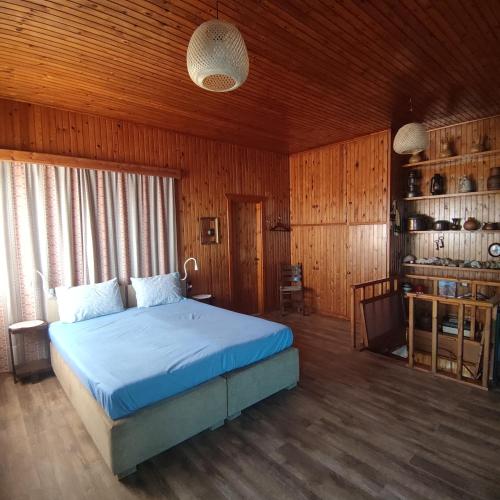 a bedroom with a bed and a wooden ceiling at Rising Sun Guesthouse in Mesokhória