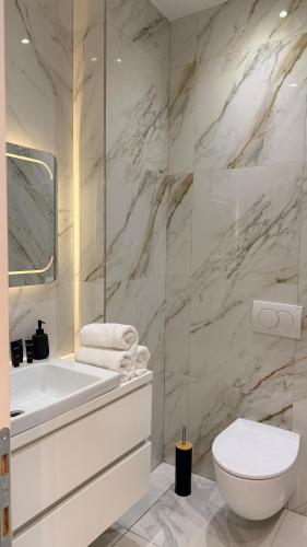 a white bathroom with a sink and a toilet at Dream Suites - Lake View Residences in Tirana
