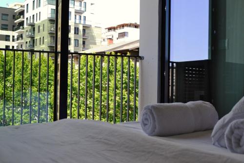 a bedroom with a bed and a balcony with a view at Dream Suites - Lake View Residences in Tirana