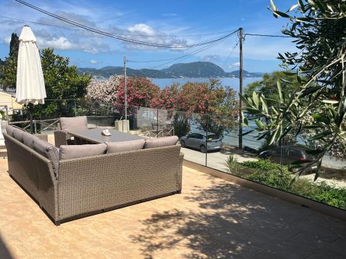a wicker couch on a patio with a view of the water at Boukari Blu Studio Boukari Beach in Boukari