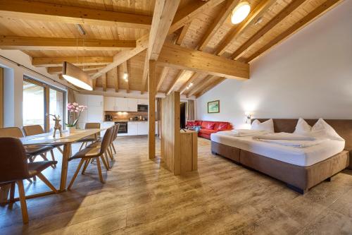 a bedroom with a large bed and a dining room at AlpenParks Hotel & Apartment Sonnleiten in Saalbach-Hinterglemm