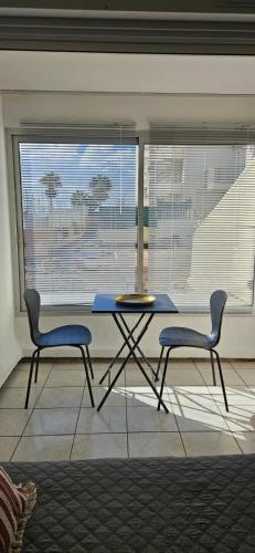 a table and two chairs in front of a window at Le paradis du Port Cozy studio near port and beaches in Cap dAgde in Cap d'Agde
