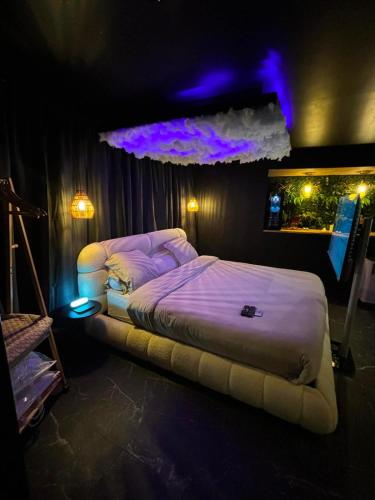 a bedroom with a large bed with purple lighting at L'écrin Secret Suite & NETFLIX Aubagne-Cassis-Marseille in Aubagne
