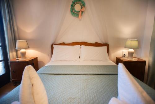 a bedroom with a bed with two lamps and two chairs at EMPHASIS Traditional House with Jacuzzi & Bicycles in Apodhoúlou