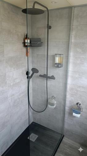 a shower with a glass door in a bathroom at Beach apartment - Ocean sunset full view in Meschers-sur-Gironde