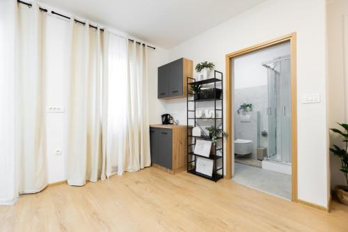 a living room with white curtains and a bathroom at Apartmani Triluna in Drškovci