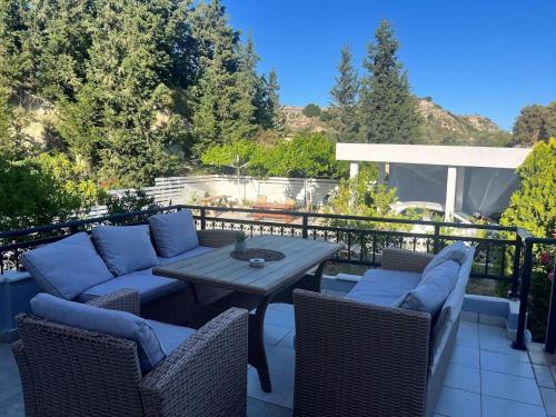 a patio with a table and chairs on a balcony at Seascape Village - Spacious 3-Bed Apartment with Private Garden and Parking in Kalithies