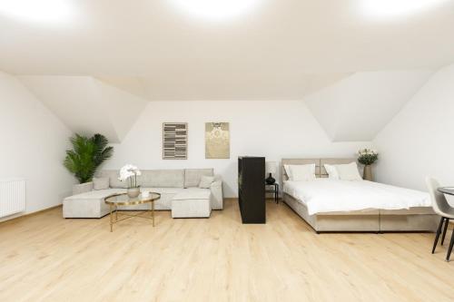 a white living room with a bed and a couch at Apartmani Triluna in Drškovci