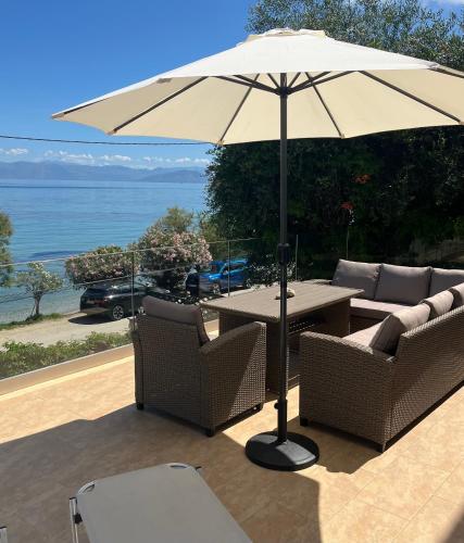 a table and chairs with an umbrella on a patio at Boukari Blu Studio Boukari Beach in Boukari