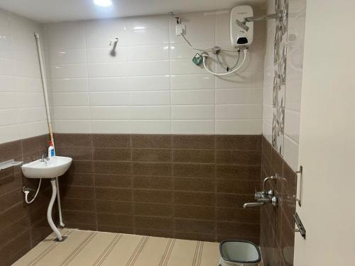 a bathroom with a shower with a sink and a toilet at Aerodon resort in Chennai