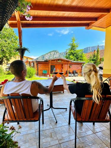 a man and woman sitting in chairs drinking wine at Ramonda Serbica - Gorge View & Peacful Nature Retreat in Niš
