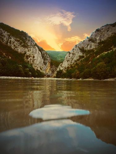 a view of a river with the sun setting at Khidikari Hotel in Ambrolauri