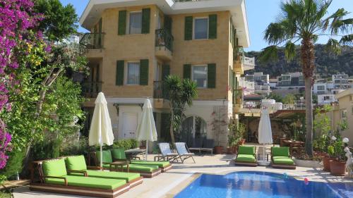 a hotel with a pool and chairs and a building at Villa Grande Kalkan in Kaş
