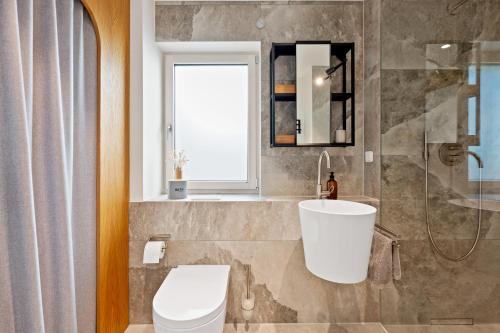 a bathroom with a toilet and a sink and a window at Appartment SPATZENNEST in Bietigheim-Bissingen
