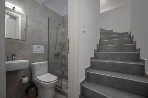 a bathroom with a toilet and a staircase at SLV Dionysos Apartment in Ofrínion