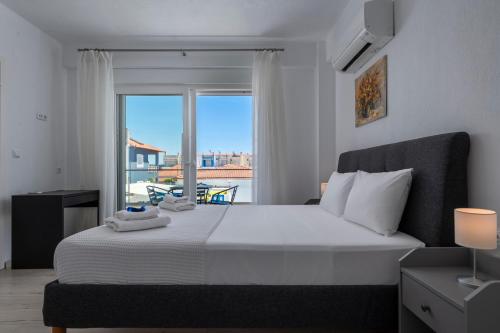 a bedroom with a large bed and a window at SLV Dionysos Apartment in Ofrínion