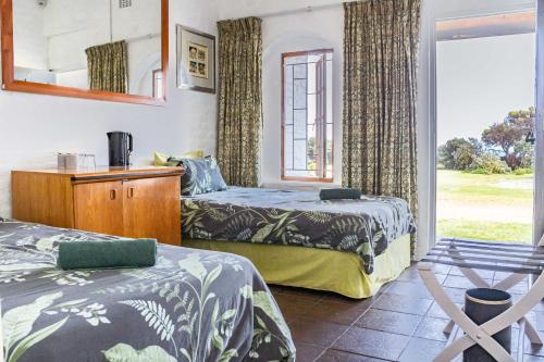 a bedroom with two beds and a window at The Hangklip Hotel in Pringle Bay
