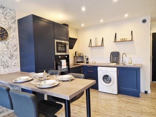 a kitchen and dining room with a table and a washer at Le Key Largo in Cherbourg en Cotentin