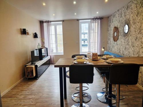 a dining room with a table and chairs in a room at Le Key Largo in Cherbourg en Cotentin