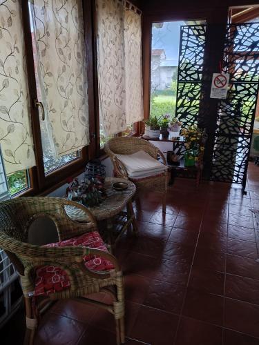 a room with chairs and a table and windows at B&B Coccinella in Basiliano