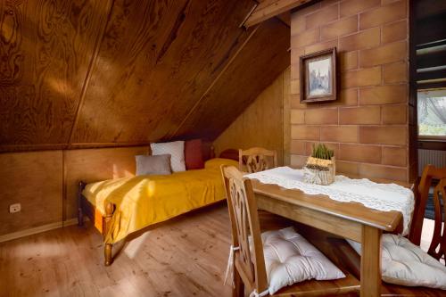 a bedroom with a bed and a table in a room at Mały Domek in Stara Rzeka