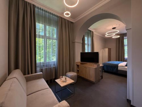 a living room with a couch and a bed at Schlosshotel Grünwald in Grünwald