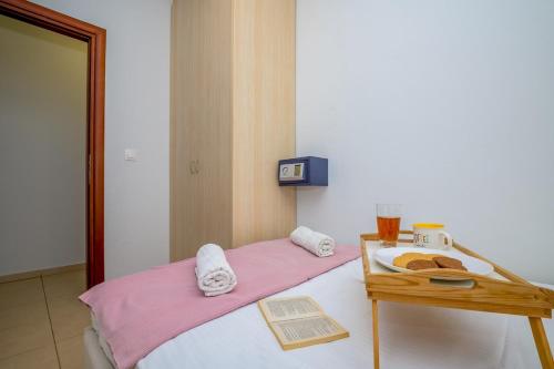 ein Bett mit einem Tisch, auf dem ein Tablett mit Essen steht in der Unterkunft Demi Panda in Orestiada