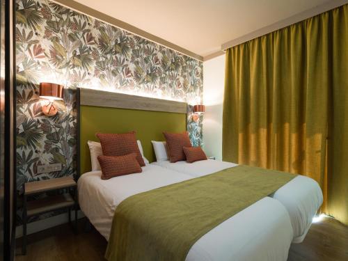 a bedroom with two beds and a green wall at Servatur Doña Elvira in Puerto Rico de Gran Canaria