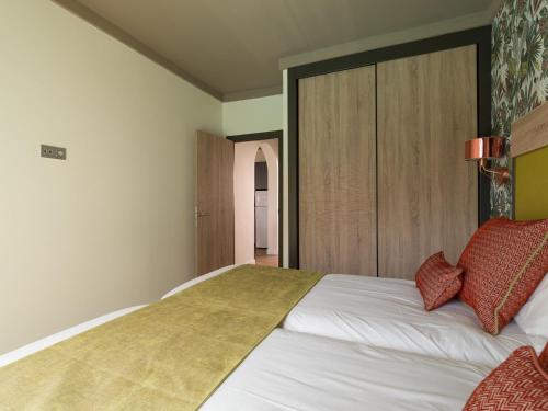 a bedroom with a large white bed with red pillows at Servatur Doña Elvira in Puerto Rico de Gran Canaria
