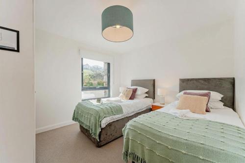 a bedroom with two beds and a window at Residence Number 5 - Luxury 2 Bed Ground Floor Apartment By Together Travel in Nefyn
