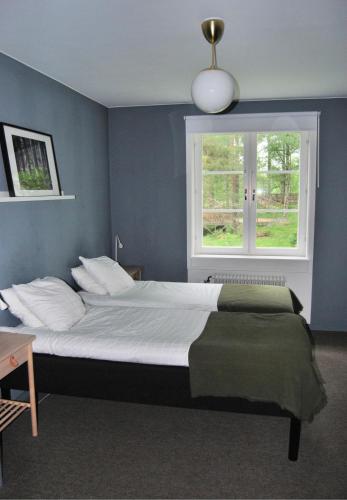 a bedroom with a large bed with a window at Nordsjögården in Järvsö