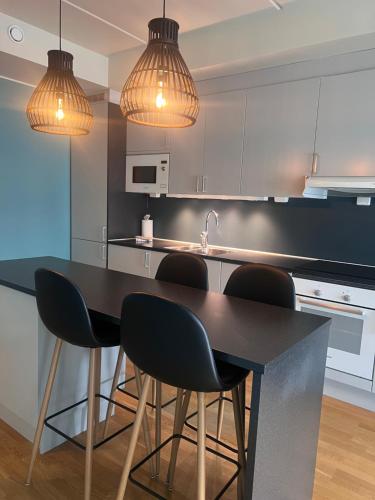a kitchen with a black table and chairs at City apartment in Alta