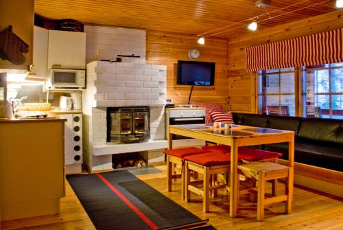 a kitchen and living room with a table and a stove at Kutusumppu A in Tahkovuori