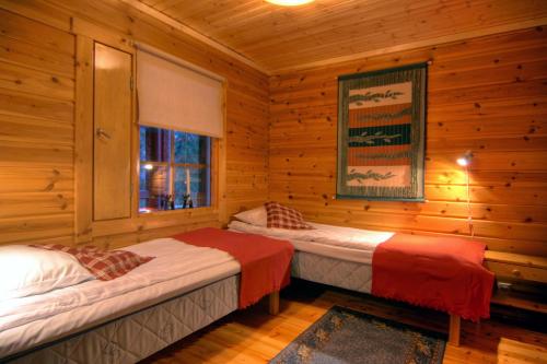 a bedroom with two beds in a log cabin at Kutusumppu A in Tahkovuori