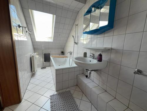 a white bathroom with a sink and a tub at Zentral Z in Siegen