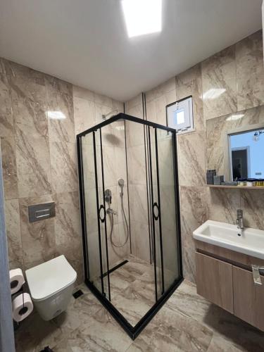 a bathroom with a shower and a toilet and a sink at Parli Hotel in Gokceada Town