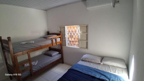 a bedroom with two bunk beds and a window at Casa de férias Pôr do Sol 4 in Bataguaçu
