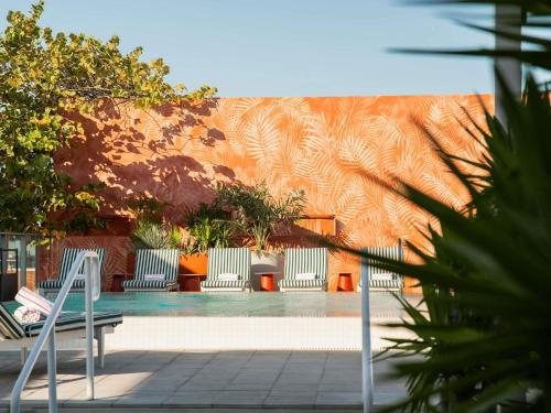 a swimming pool with two chairs and a building at Novotel Miami Brickell in Miami
