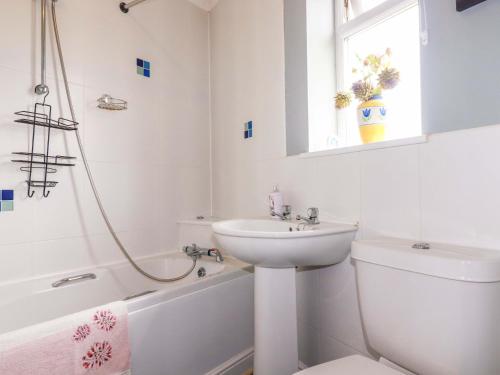 a white bathroom with a sink and a toilet at Treetops in Par